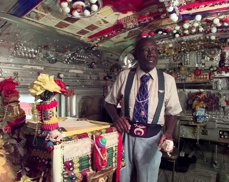 In this 1998 photo, the Rev. Herman D. Dennis poses inside "The House of Prayer," an ornately decorated school bus at his home at Margaret's Grocery near Vicksburg, Miss.