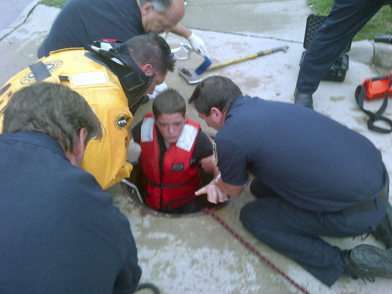 Firefighters rescue 14-year-old Jeffrey LaPorta from a manhole Tuesday in Parma, Ohio, in this photo supplied by the fire department. Authorities say LaPorta fell off his bike, was swept by flood waters into city sewer pipes, and traveled more than a quarter of a mile, at times completely submerged, before he found enough breathing room to await rescue.