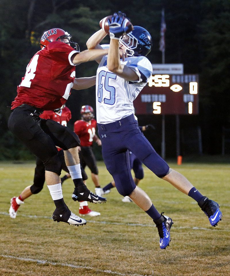 Aaron Duncanson of Westbrook hauls in a first-quarter pass Friday night as Joey Spinelli defends for Wells. Westbrook earned a 28-20 victory on the road.