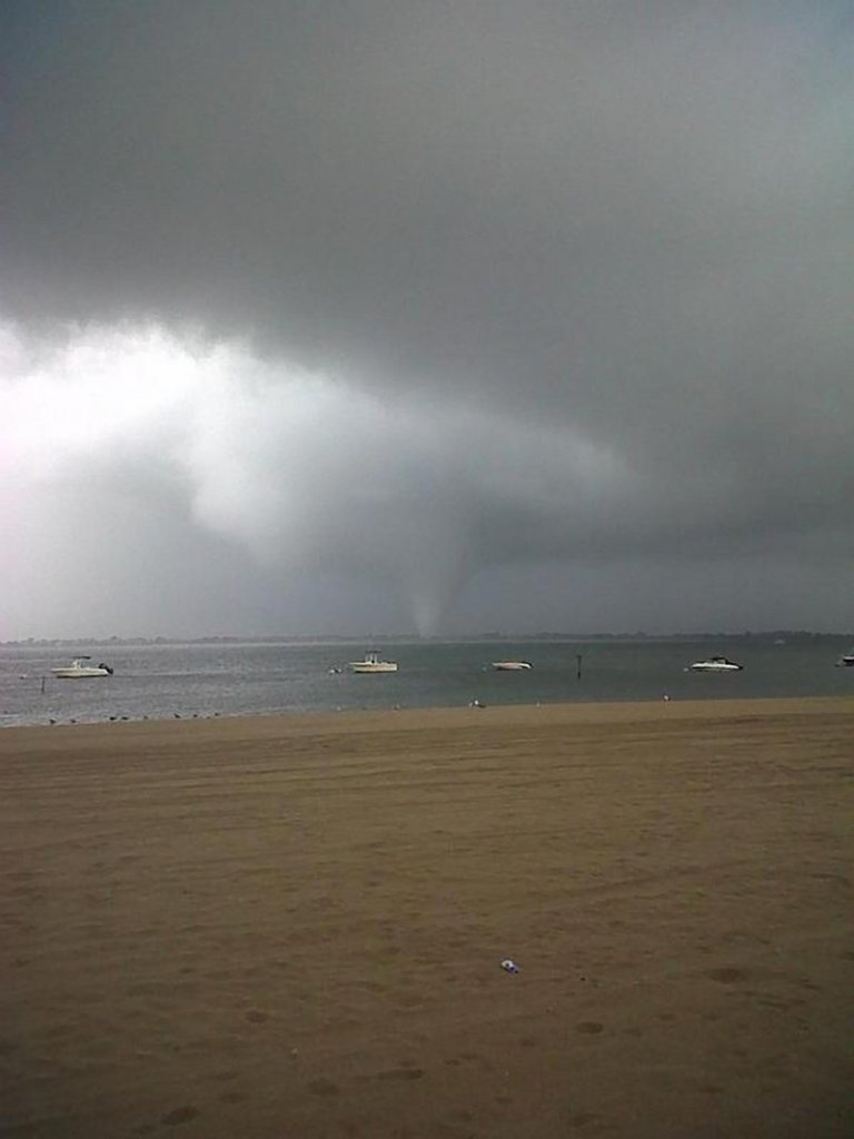 A funnel cloud forms over the Breezy Point section of the Rockaway peninsula in the Queens borough of New York on Saturday. No serious injuries were reported.