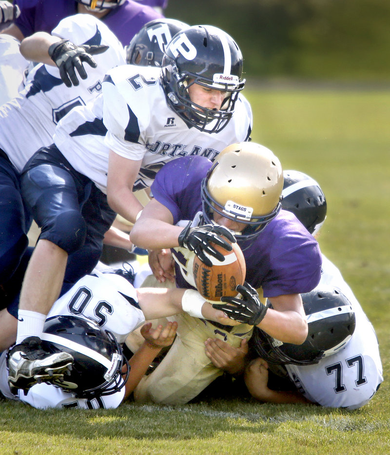 Cheverus running back Cody O’Brien is tackled by Portland’s Anthony Lane, bottom left, Joe Nielsen, top, and Cody McCormack. Cheverus won, 42-0.