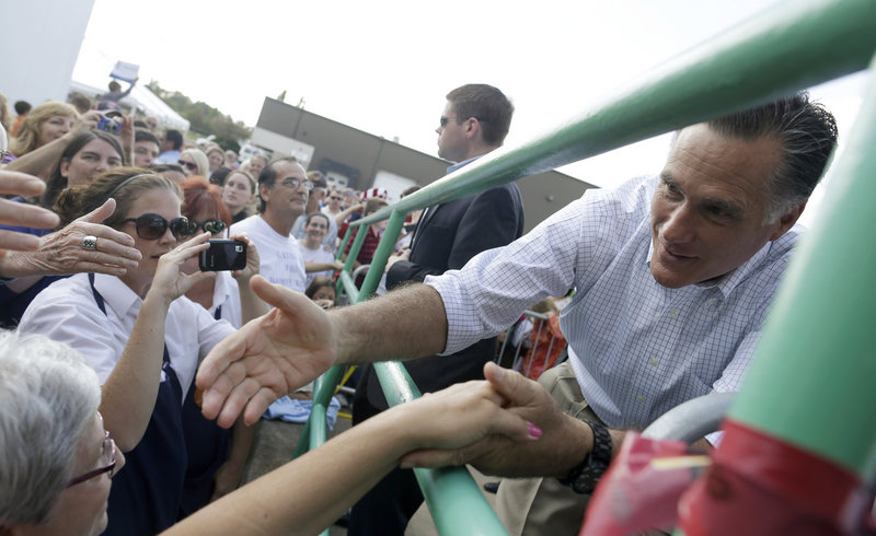 Republican presidential candidate Mitt Romney greets an overflow crowd as he campaigns at PR Machine Works in Mansfield, Ohio, on Monday.