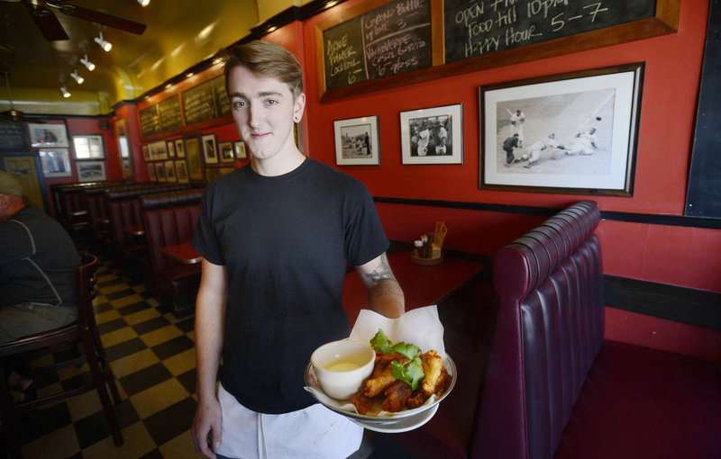 Tanner Gasco-Wiggin shows off a plate of wings at Downtown Lounge in Portland.