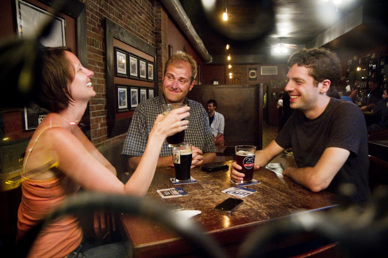 Ashley Hanamann, Bryan McLeod and Ethan Jud, all of Portland, chat over beers at The Snug.