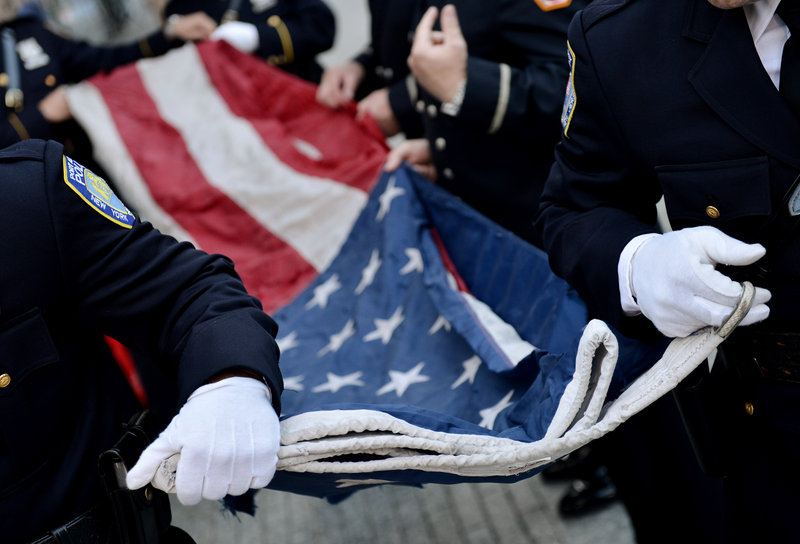 Police officers of the Port Authority of New York and New Jersey carry a U.S. flag that once flew over the World Trade Center towers.