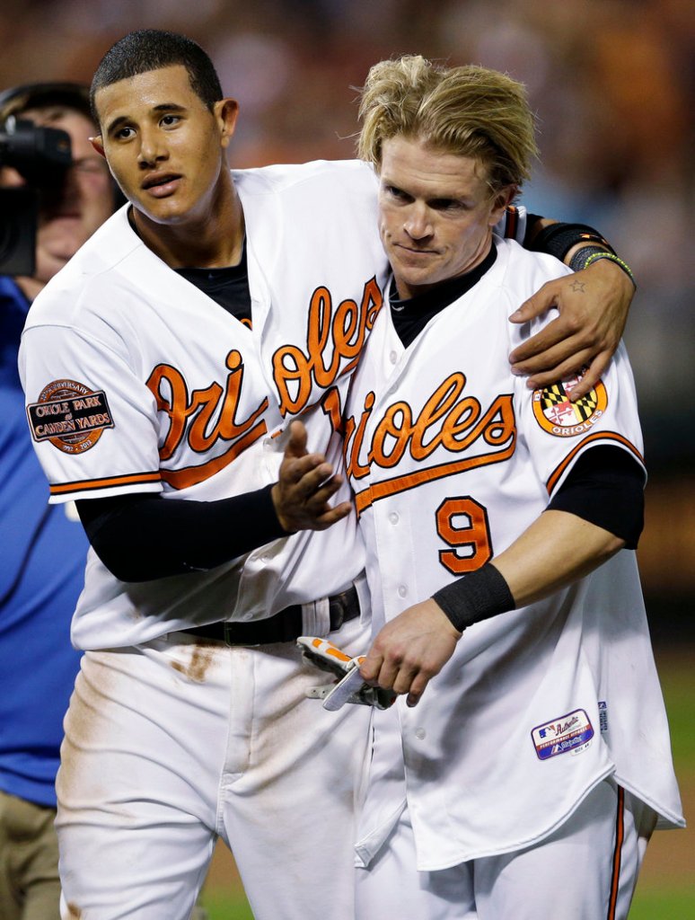 Manny Machado, left, celebrates with Nate McLouth after scoring the winning run on McLouth’s single in the ninth inning Wednesday night against Tampa Bay.
