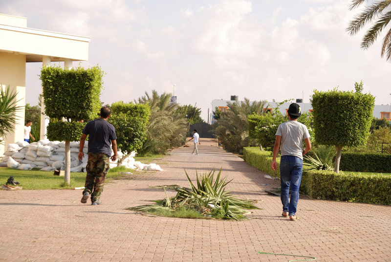 Libyans walk on the grounds of the U.S. consulate in Benghazi, Libya, after a militant attack Tuesday left four Americans dead, including Ambassador Chris Stevens, 52.