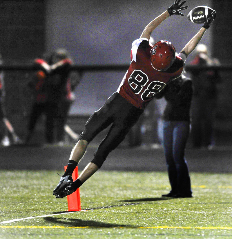 Greg Viola of Scarborough leaps to haul in a pass from Dillon Russo in the end zone Friday night, completing a 30-yard play in the first quarter and giving the Red Storm their second touchdown on the way to a 27-12 victory against Windham.