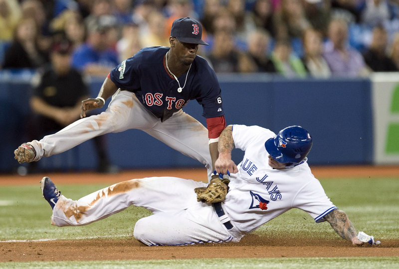 Boston’s Pedro Ciriaco tags Toronto’s Brett Lawrie at third base in the eighth inning of an 8-5 win by the Red Sox at Toronto Friday. The Red Sox blew an early 5-3 lead, coming back to snap a six-game losing streak against Toronto.