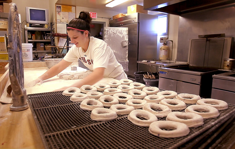 Emily Bachelder, a baker at Tony’s Donuts in Portland, gathers flour while making blueberry cake donuts. A new Tony’s Donuts will open soon in South Portland. “During the hard economic times, the bakery business is always good,” says Rick Fournier, Tony’s owner.