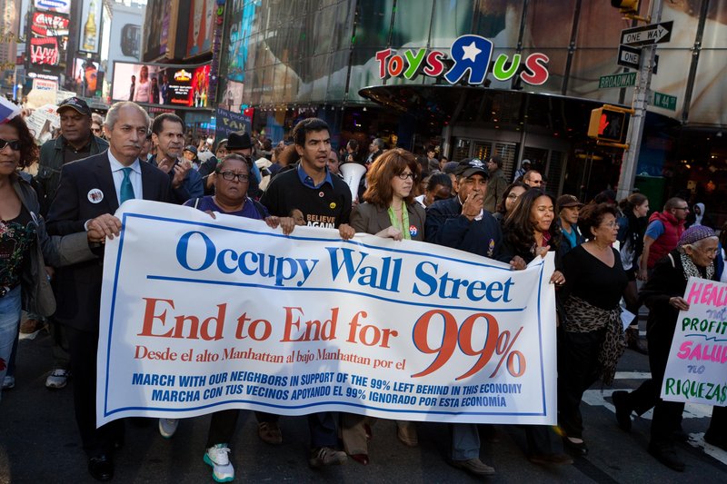 Occupy Wall Street protesters walk through Times Square on Nov. 7, 2011. On Monday, the formation of a “people’s wall” around the New York Stock Exchange is planned to mark a year since the occupation of a park near Wall Street.