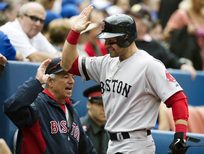 Boston’s Cody Ross has a high-five ready as he heads to the dugout after his leadoff homer in the second inning – his 21st of the year – in the 3-2 win at Toronto on Saturday.