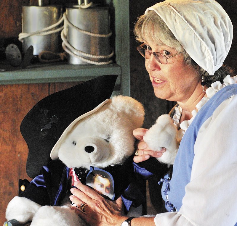 Bonnie Wilder, a member of the Daughters of the American Revolution, talks about a Patrick Henry toy bear as she begins her “Meet the Framers of the Constitution” program that was part of the events at Old Fort Western in Augusta on Saturday.