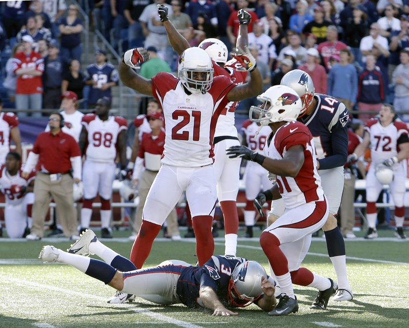 Arizona players celebrate after Stephen Gostkowski, bottom, missed a 42-yard field goal with one second remaining, enabling the Cardinals to hold on for a 20-18 win over the Patriots.