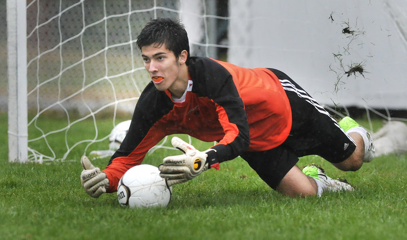 Biddeford goalie Josh McCauley dives the right way Tuesday and stops a penalty kick by Portland during their schoolboy soccer game at Biddeford. The teams finished in a 2-2 tie.