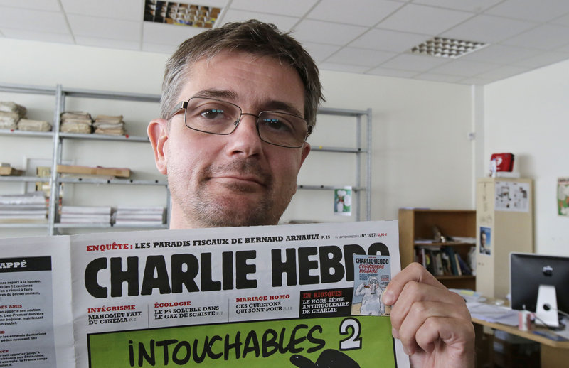 Stephane Charbonnier, who goes by Charb, displays a copy of the satirical French weekly Charlie Hebdo in Paris Wednesday. He is the chief editor or the newspaper.