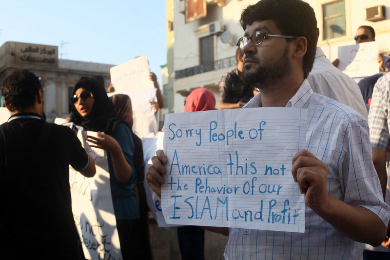 A Libyan man holds a placard in English while demonstrating Sept. 12 against the attack on the U.S. consulate that killed four Americans in Benghazi, Libya.