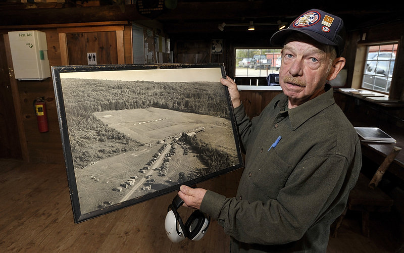 Gunnar Gundersen, the Lincoln County Rifle Club president, shows an old photo of the club’s land. “We try to be good neighbors,” said Gundersen, a member for 40 years.