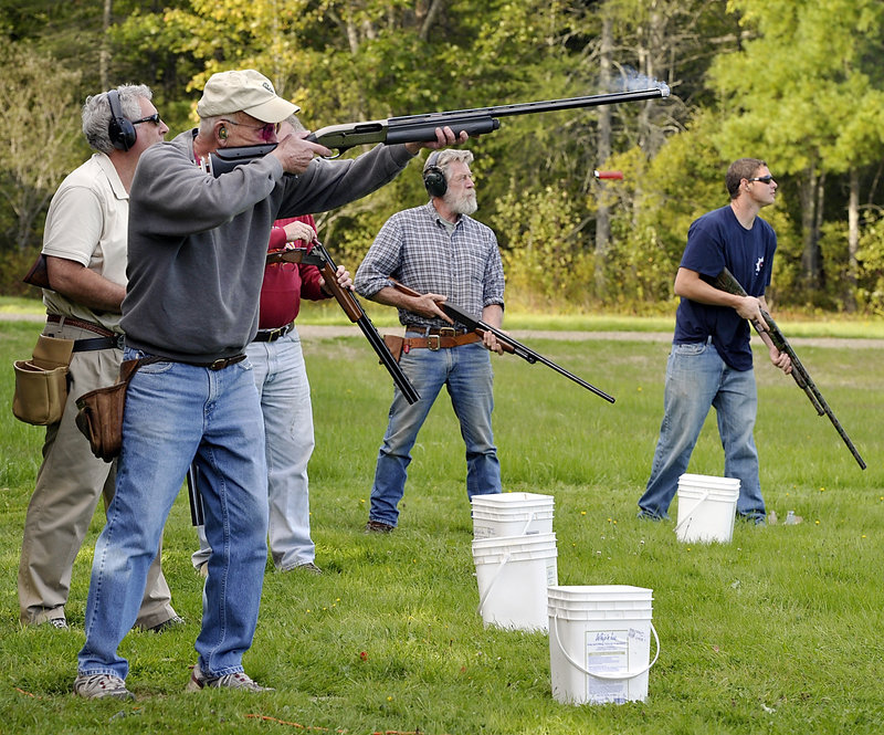 Jerry Packard of Bremen, with fellow shooters at the Lincoln County Rifle Club in Damariscotta, fires at a “clay pigeon” target tossed in the air by an Old Western trap machine. The 400-member club is 80 years old, but many are concerned it could someday be threatened by development on adjacent lots.