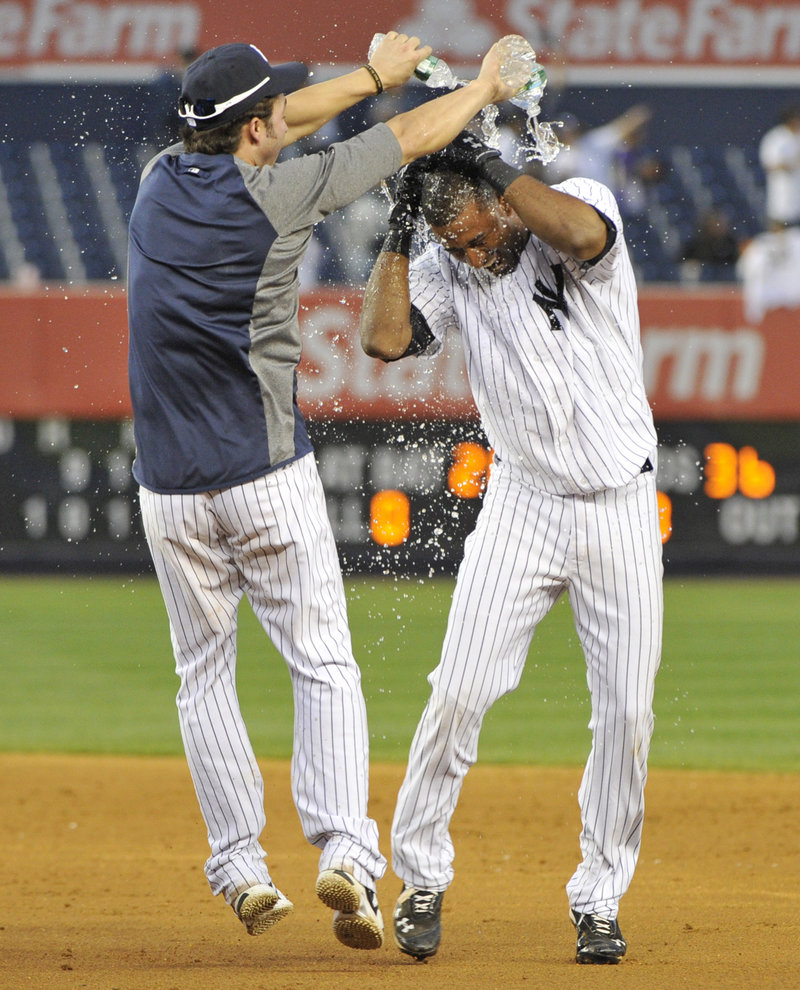 Eduardo Nunez, right, celebrates with Nick Swisher after the Yankees rallied to beat Oakland 10-9 in 14 innings Saturday.