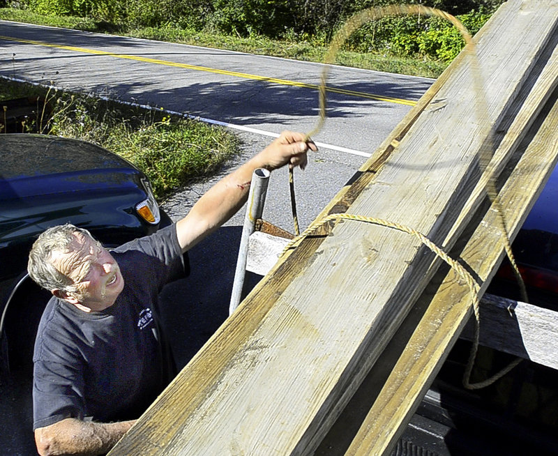 Adrian Hooydonk unties lumber from his pickup truck last week at his home in Spruce Head. The lobster buyer doesn’t approve of everything President Obama has done, but blames Republicans for being obstructionist.