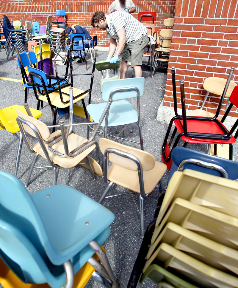 Michael Madison, a custodian at Presumpscot Elementary School, cleans chairs outside Cathedral School in Portland on Monday, Sept. 24, 2012. Custodians, city employees and teachers prepared the school for Hall Elementary students, who will begin classes at Cathedral on Tuesday.