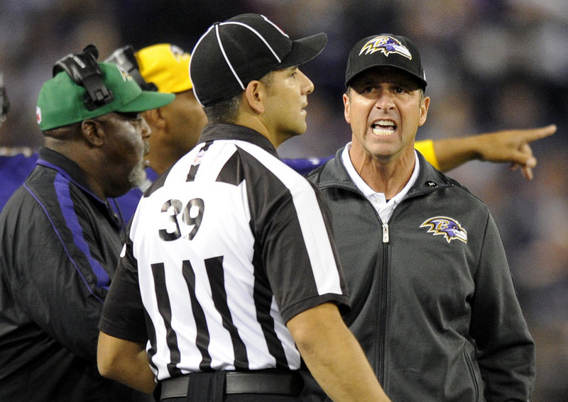 Ravens head coach John Harbaugh questions line judge Esteban Garza during Sunday’s game against the Patriots. An NFL executive is reviewing the conduct of the coaches.