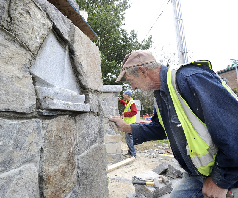 Ronald Bourassa, a stonemason from Buxton with ties to South Portland, works on a pillar that holds one of a pair of granite Friendship sloops he carved himself and added to the stonework being done at Mill Creek Park.