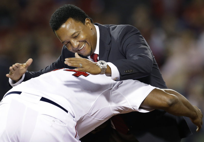 Pedro Martinez is greeted by David Ortiz – teammates when the Red Sox were contenders – during a ceremony Wednesday night honoring the top 40 players in franchise history.