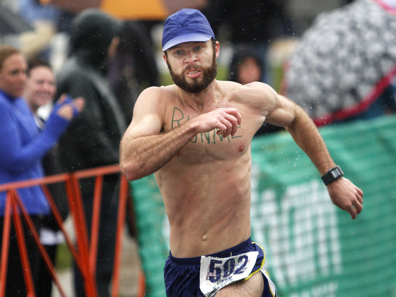 Owen Bradley of Birmingham, Ala., sprints through the raindrops Sunday to reach the finish line and complete his outing in the Maine Marathon at Portland.