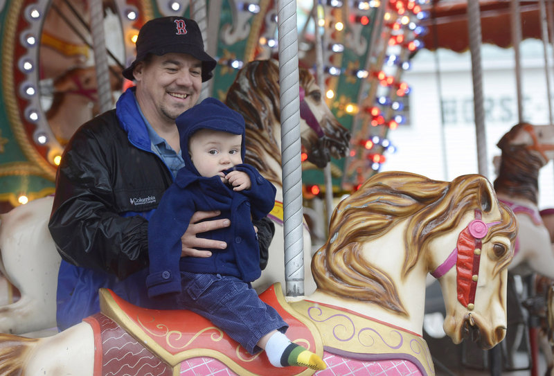 Kempton Rich of Sebago holds his 13-month-old son, Kayden, on the merry-go-round at the Fryeburg Fair on Sunday. It was Kayden’s first ride on a merry-go-round.