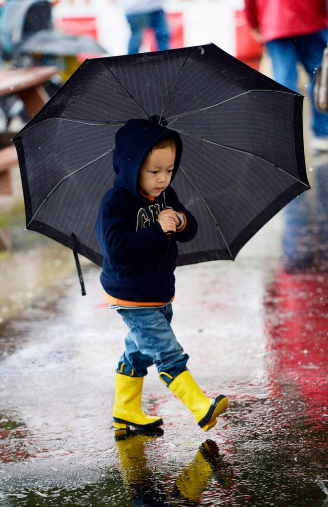 Eric Buehler, 3, of Boxford, Mass., is ready for the weather with an umbrella and bright rain boots at the Fryeburg Fair.
