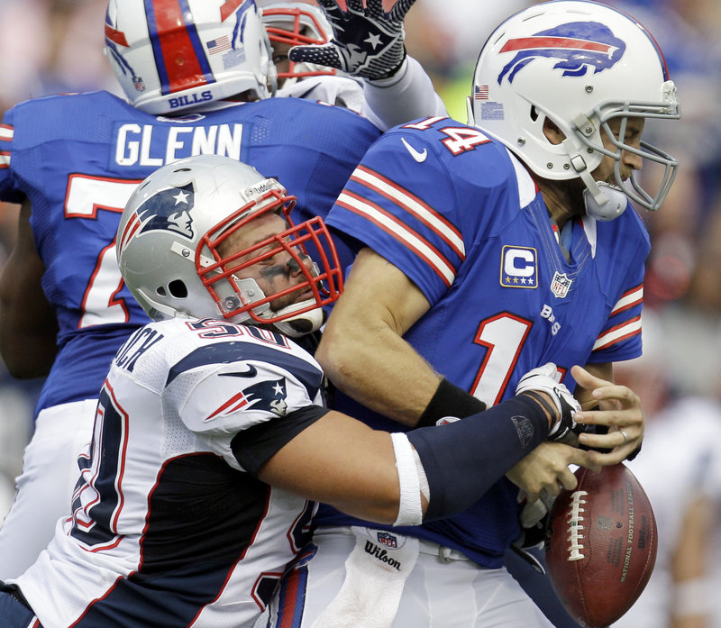 Buffalo quarterback Ryan Fitzpatrick has the ball knocked away by Rob Ninkovich of New England during the second quarter of the Patriots’ 52-28 victory Sunday.