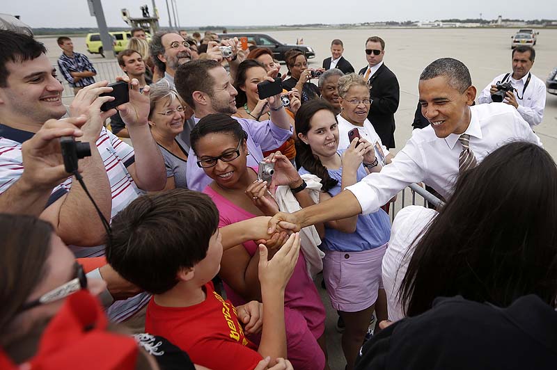 President Barack Obama greets guests on the tarmac upon his arrival at Des Moines International Airport, Saturday in Iowa.