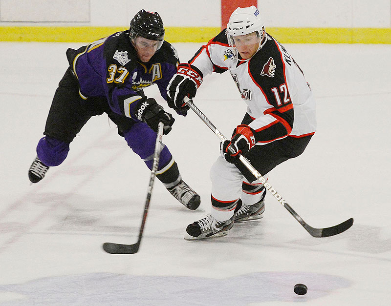 Thomas Hickey of Manchester battles for the puck with Portland's Rob Klinkhammer in an exhibition game Sunday at the Portland Ice Arena. The Pirates lost to the Monarchs on Monday for the second time in as many days.