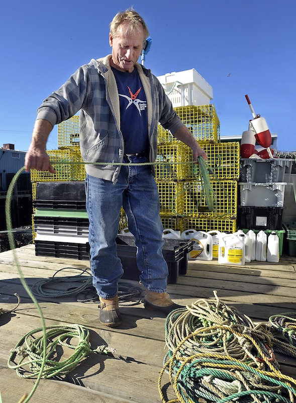 Lobsterman Jim Holden, working on Widgery Wharf in Portland on Thursday, prepares to move his traps into deeper water in advance of next week’s arrival of Hurricane Sandy. “I think I lost 300 traps” during the “perfect storm” of 1991, he said. “I hope I don’t get bit that bad again.”