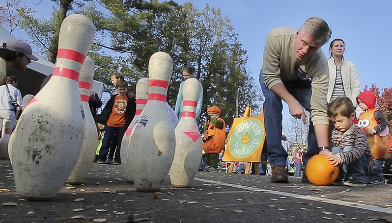 Republican Charlie Summers helps his son Thomas bowl during the Camp Sunshine Pumpkin Festival at L.L. Bean in Freeport.