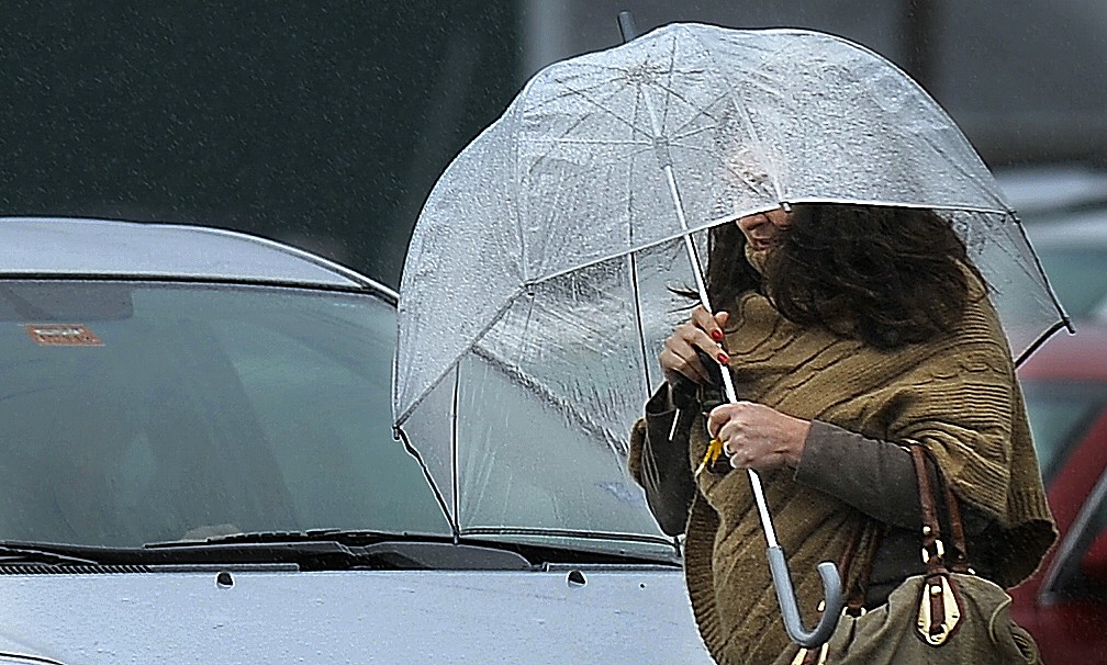 Laura Gough of Cape Elizabeth shields herself with an umbrella as she walks to work on Commercial Street Monday morning, October 29, 2012.