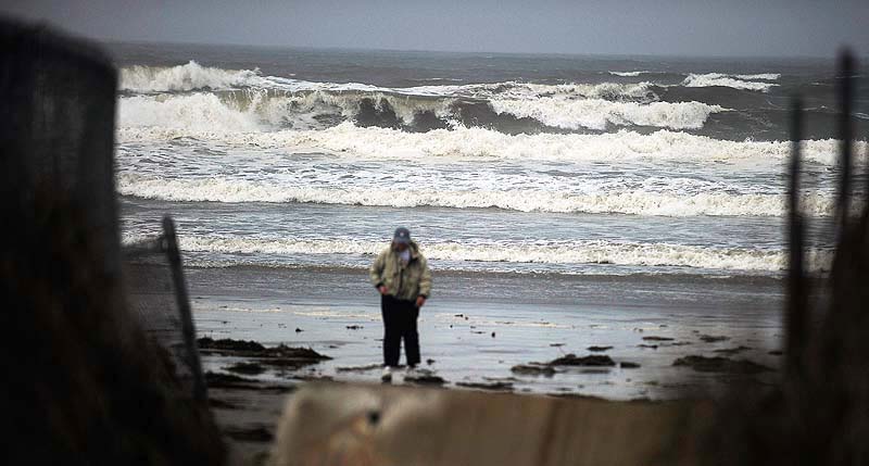 Diane Visch of Scarborough heads back home Tuesday morning, after checking out the heavy surf at Higgins Beach kicked up by Hurricane Sandy.