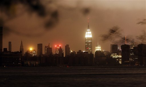 The New York skyline remains dark Monday, Oct. 29, 2012, as seen from the Williamsburg neighborhood in the Brooklyn borough of New York. In an attempt to lessen damage from saltwater to the subway system and the electrical network beneath the city's financial district, New York City's main utility cut power to about 6,500 customers in lower Manhattan. But a far wider swath of the city was hit with blackouts caused by flooding and transformer explosions. (AP Photo/Frank Franklin II)