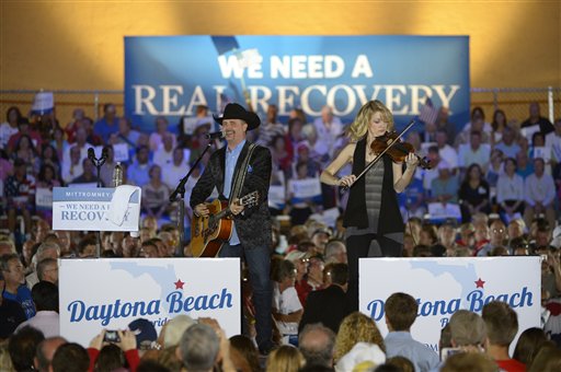 FILE - In this Oct. 19, 2012 file photo, country music singer John Rich, left, performs before Republican presidential candidate, former Massachusetts Gov. Mitt Romney and his vice presidential running mate Rep. Paul Ryan, R-Wis., arrived during the Romney Ryan Victory Rally in Daytona Beach, Fla. Dozens of celebrities, elected officials, and others are blitzing through battleground states in the White House race�s final days. Their goal: give the presidential campaigns a daily presence in key states even when the men at the top of the ticket (and their running mates) pitch for votes elsewhere. (AP Photo/Phelan M. Ebenhack, File)