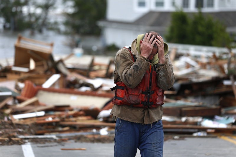Brian Hajeski, 41, of Brick, N.J., reacts after looking at debris of a home that washed up on to the Mantoloking Bridge the morning after superstorm Sandy rolled through, Tuesday, Oct. 30, 2012, in Mantoloking, N.J. Sandy, the storm that made landfall Monday, caused multiple fatalities, halted mass transit and cut power to more than 6 million homes and businesses. (AP Photo/Julio Cortez)