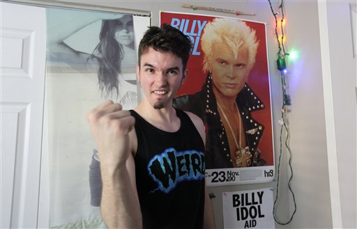 Michael Henrichsen poses recently in his bedroom in Seattle next to a poster of rock star Billy Idol. Henrichsen created a website and enlisted friends and celebrities around the world in a two-year effort to convince Idol to come play a concert on Oct. 26, 2012, at a Seattle music venue to raise money for charity and celebrate Henrichsen's birthday.