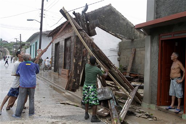 Men try to free an electrical wire after the passing of Hurricane Sandy in Gibara, Cuba, on Thursday. Power was turned off as the hurricane blasted across eastern Cuba as a potent Category 2 storm.