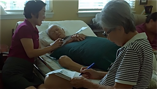 In this Oct. 17, 2012, photo provided by Irene Tanabe, Frank Tanabe, center, gets help from his daughter Barbara Tanabe, left, to fill out his absentee ballot in Honolulu while his wife Setsuko Tanabe sits in the foreground.