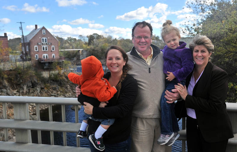 Greg and Paula Dore pose for a picture with daughter-in-law Christen Dore, left, and grandchildren Bentley, 1, and Marley, 4, on the Margaret Chase Smith Bridges with the Old Mill Pub in the background, on the left, in Skowhegan on Thursday.
