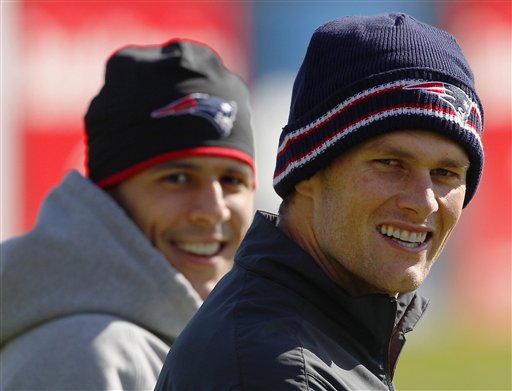 New England Patriots quarterback Tom Brady, right, and tight end Aaron Hernandez walk onto the practice field for a walk-through at the team's NFL football training facility in Foxborough, Mass., on Wednesday.