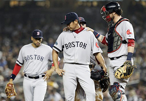 Teammates console starting pitcher Daisuke Matsuzaka, center, before Matsuzaka was pulled during the third inning of the Red Sox game against the New York Yankees on Wednesday.