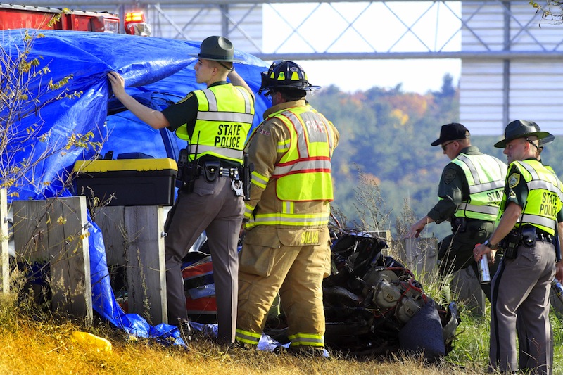 Police and fire officials examine a small plane that crashed, Thursday, Oct. 25, 2012 in Hookset, N.H. New Hampshire state police say a man and a woman died in the crash near Interstate 93 in Hooksett, N.H. (AP Photo/Jim Cole)
