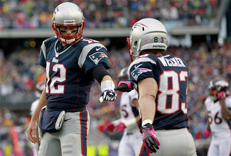 New England Patriots quarterback Tom Brady (12) fist-bumps wide receiver Wes Welker (83) after they connected for a touchdown against the Denver Broncos in the first quarter Sunday. Welker caught 13 passes for 104 yards in the game.